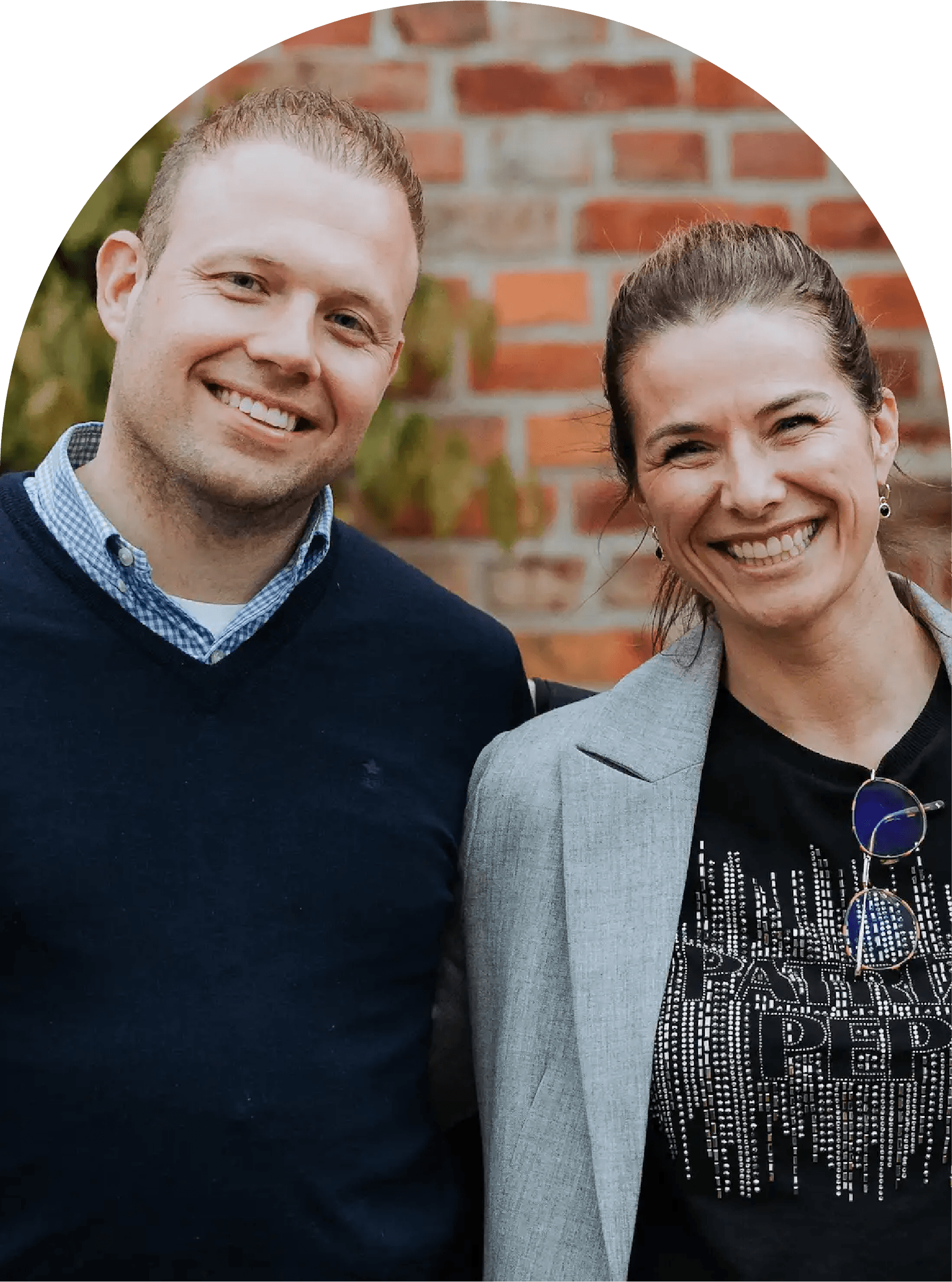 Portret van de zaakvoerders, samen glimlachend voor een bakstenen achtergrond