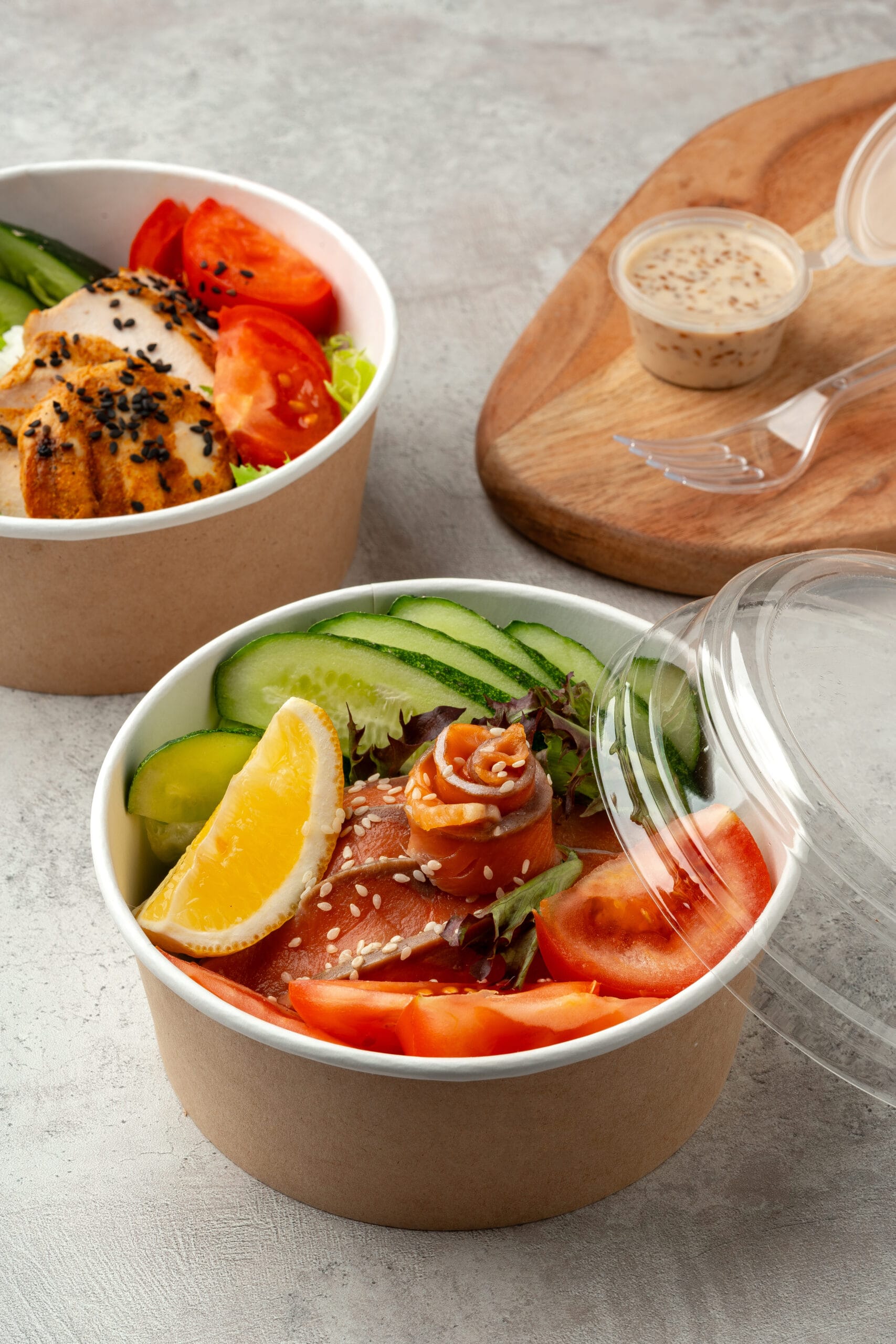 Gezonde take-away bowls met zalm, kip, verse groenten en sesamzaad